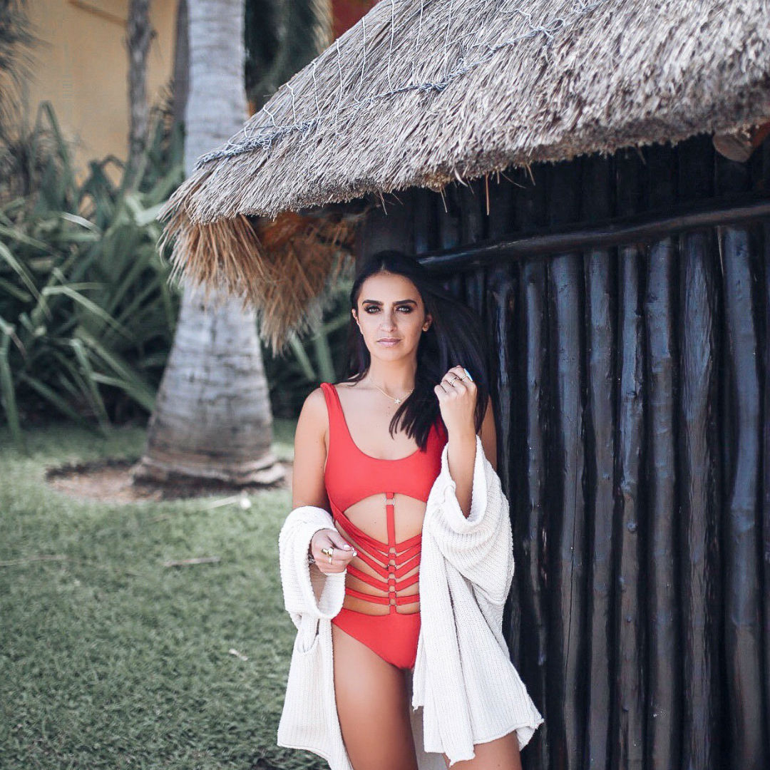 Blogger Sarah Lindner of the house of sequins wearing JETTY ONE PIECE LOVERS + FRIENDS Lovers + Friends. Red one piece swimsuit in mexico and free people beach cardigan