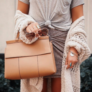 Blogger Sarah Lindner of The House of Sequins wearing Free People Saturday morning cardigan, BP twist front skirt and brown tory burch bag