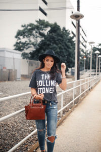 Blogger Sarah Lindner of The House of Sequins wearing AE X STONES SLEEVE PATCH GRAPHIC TEE and distressed jeans