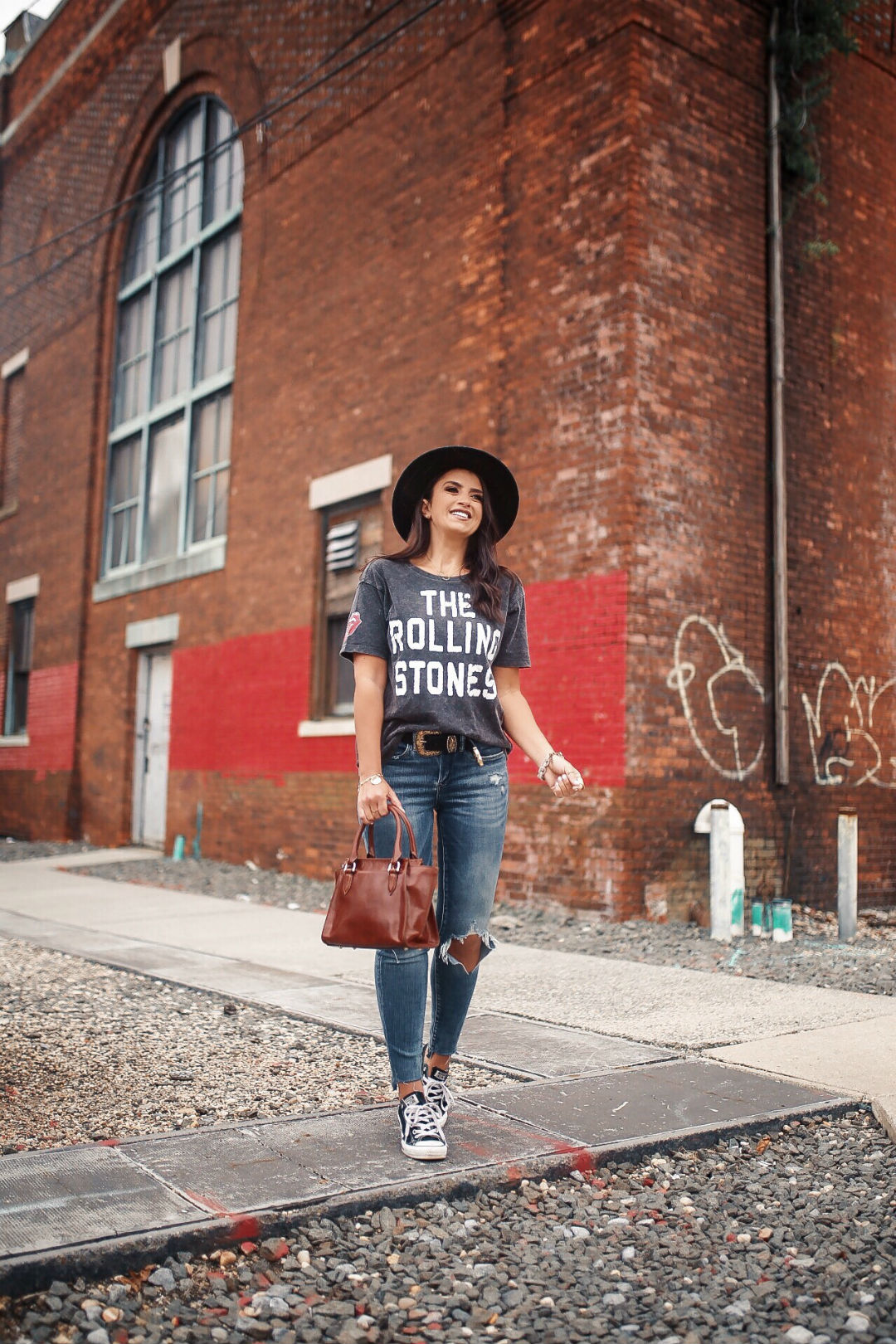 Blogger Sarah Lindner of The House of Sequins wearing AE X STONES SLEEVE PATCH GRAPHIC TEE and distressed jeans
