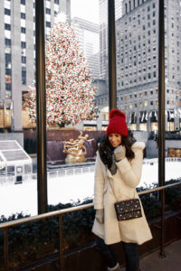 Blogger Sarah Lindner of The House of Sequins wearing Sam Edelman Fit & Flare Coat, TopShop Faux Fur PomPom Beanie and UGG Textured Fingerless Knit Gloves. What to wear to NYC in the winter or Christmas time.