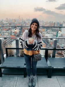 Blogger Sarah Lindner of The House of Sequins wearing Mixed Signals Mix Stripe Sweater from BlankNYC, Tory Burch Star-Stud bag, Kyi Kyi Beanie with genuine Fox Fur Pom and Sorel Joan of Arctic wedge boots. What to wear to NYC in the winter or Christmas time.