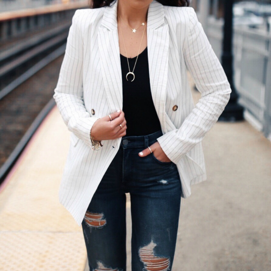 blogger Sarah Lindner of The House of Sequins wearing Express Olivia Culpo Side Cut-Out Thong Body Suit, Express Olivia Culpo Striped Boyfriend Blazer, express Striped Strap Half Moon Crossbody Bag, and express High Waisted Ripped Denim Perfect Ankle Leggings