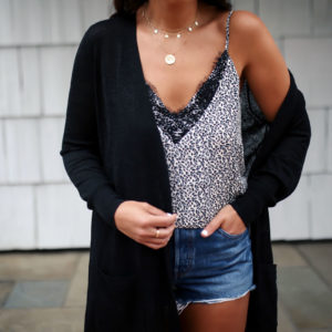 Blogger, Sarah Lindner of The House Of Sequins wearing a lace cami, Levi denim shorts and a black cardigan