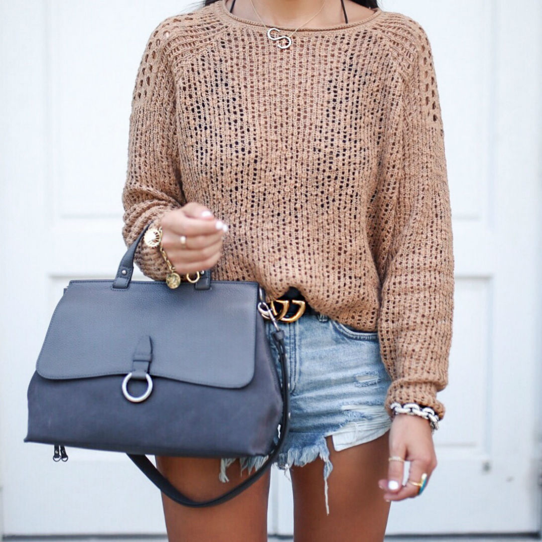Blogger, Sarah Lindner of The House Of Sequins wearing a summer sweater with a bralette and denim shorts