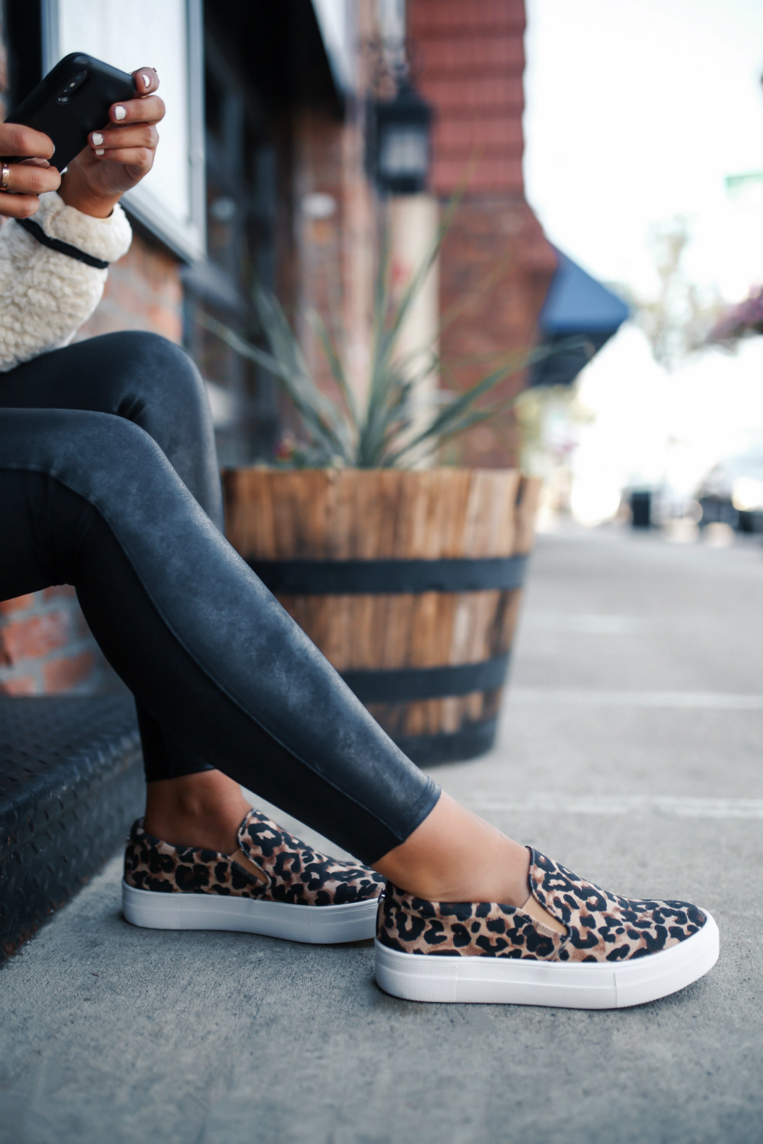 Blogger Sarah Lindner of The House of Sequins wearing Spanx Faux Leather leggings and Leopard steve madden gills slip on sneakers 