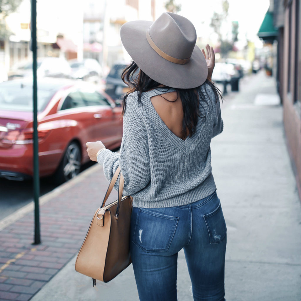 Blogger Sarah Lindner of The House of Sequins wearing express cut-out sweater, dolce vita sonni leopard booties, express mid rise medium wash ripped cropped jean leggings